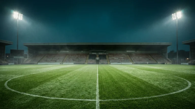 Floodlit English football stadium pitch at night with stand lights illuminated for a league bet expert preview